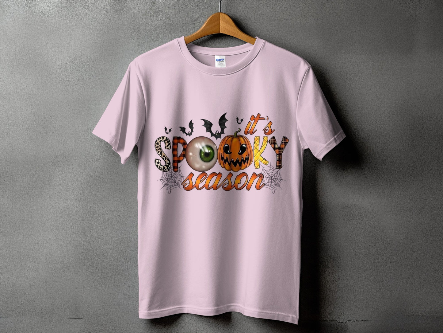 Pink t-shirt with "Spooky Season" text featuring Halloween graphics.
