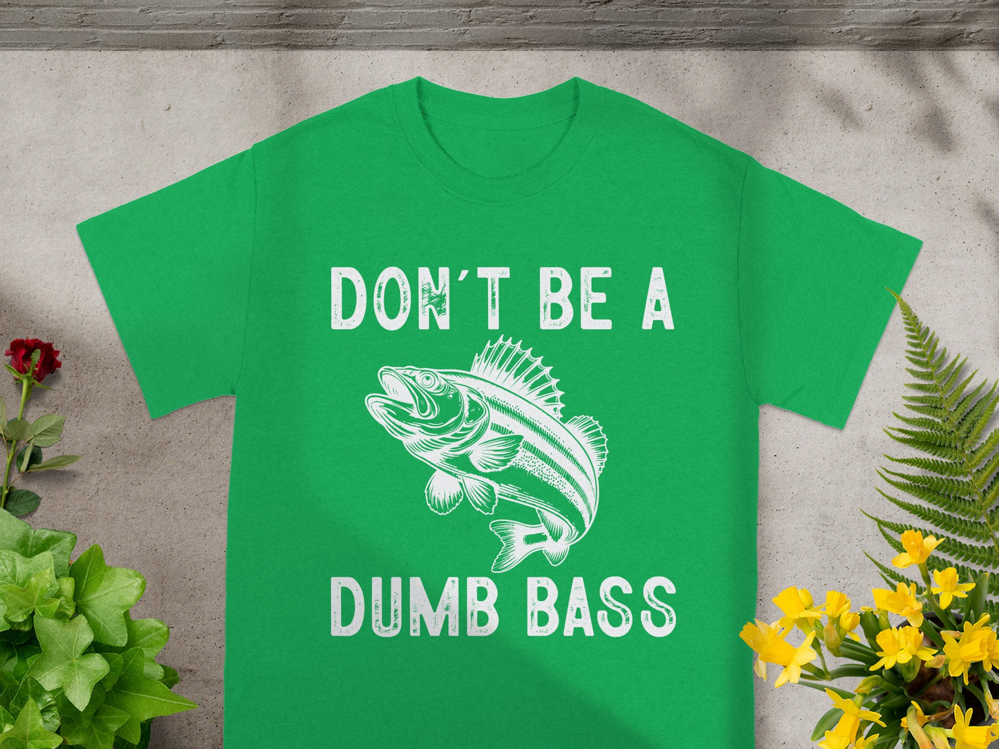 Green t-shirt with a drawing of a bass and text that reads "DON'T BE A DUMB BASS".