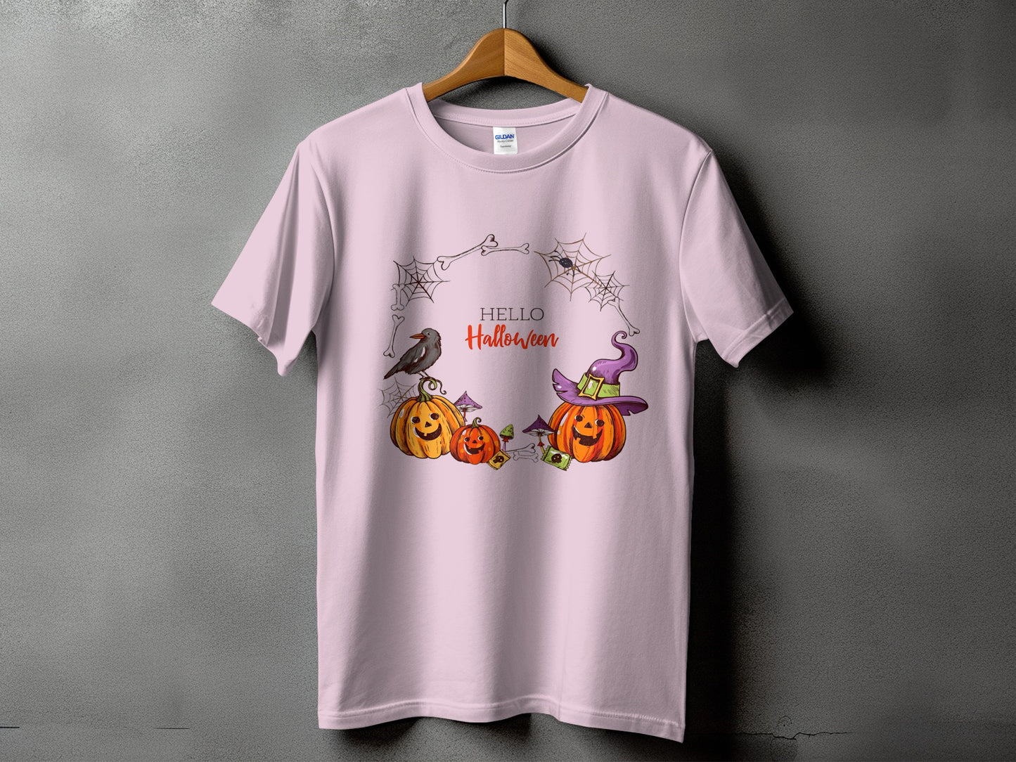 Light pink t-shirt with a Halloween graphic featuring pumpkins, a crow, and text.