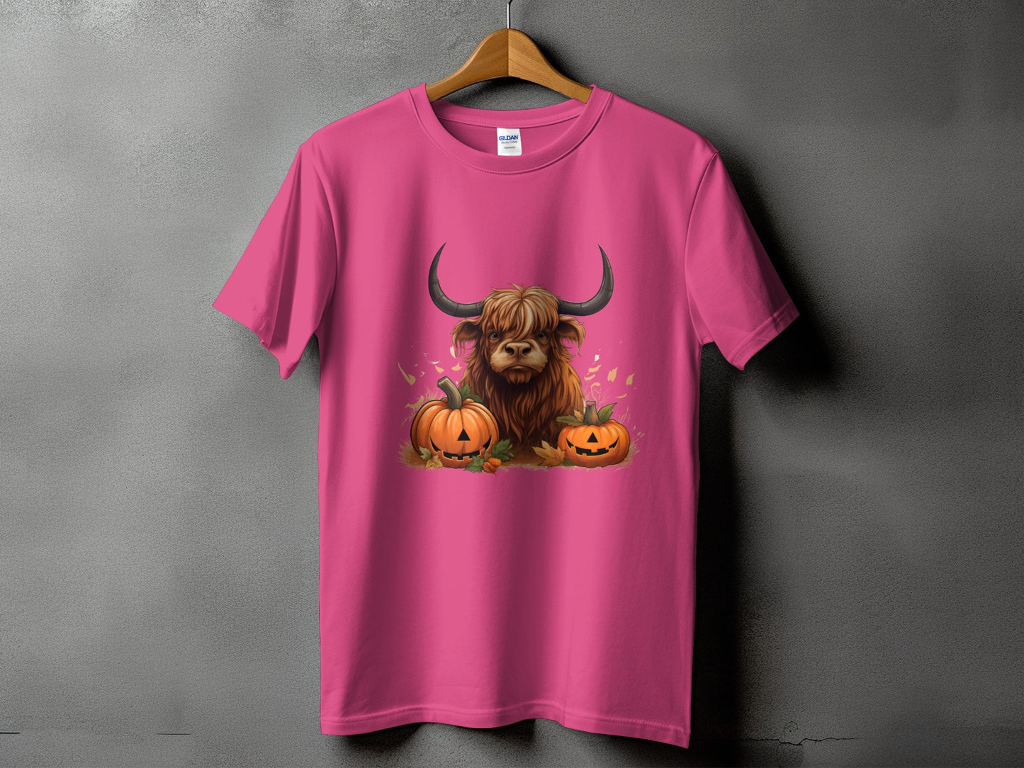 Pink t-shirt with a Highland cow and pumpkins graphic.
