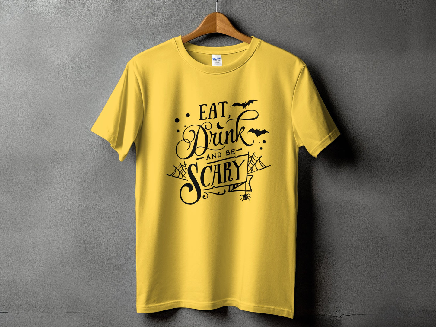 Yellow t-shirt with black text "Eat, Drink, and Be Scary" and Halloween graphics.