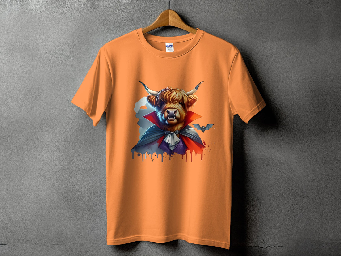Orange t-shirt with a Highland cow dressed as a vampire, with bats.