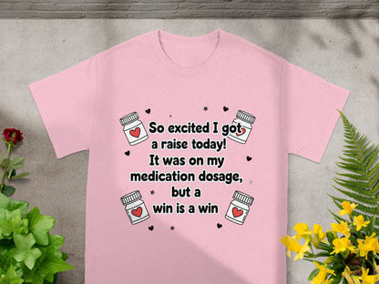 Pink t-shirt with "So excited I got a raise today! It was on my medication dosage, but a win is a win" text.