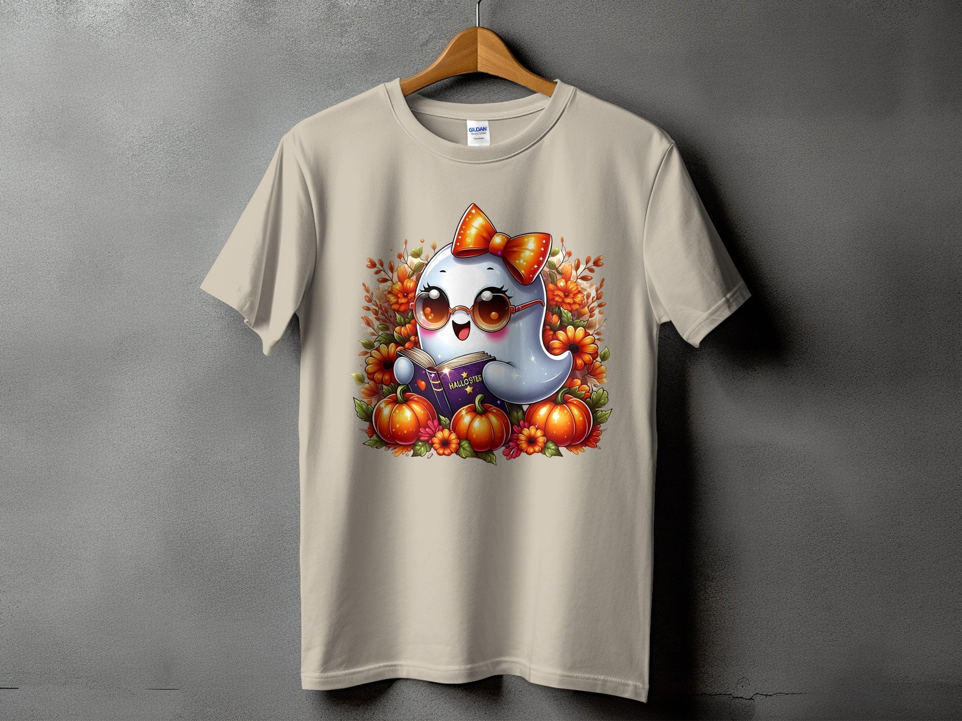 Ghost reading a Halloween book surrounded by pumpkins and flowers on a t-shirt.