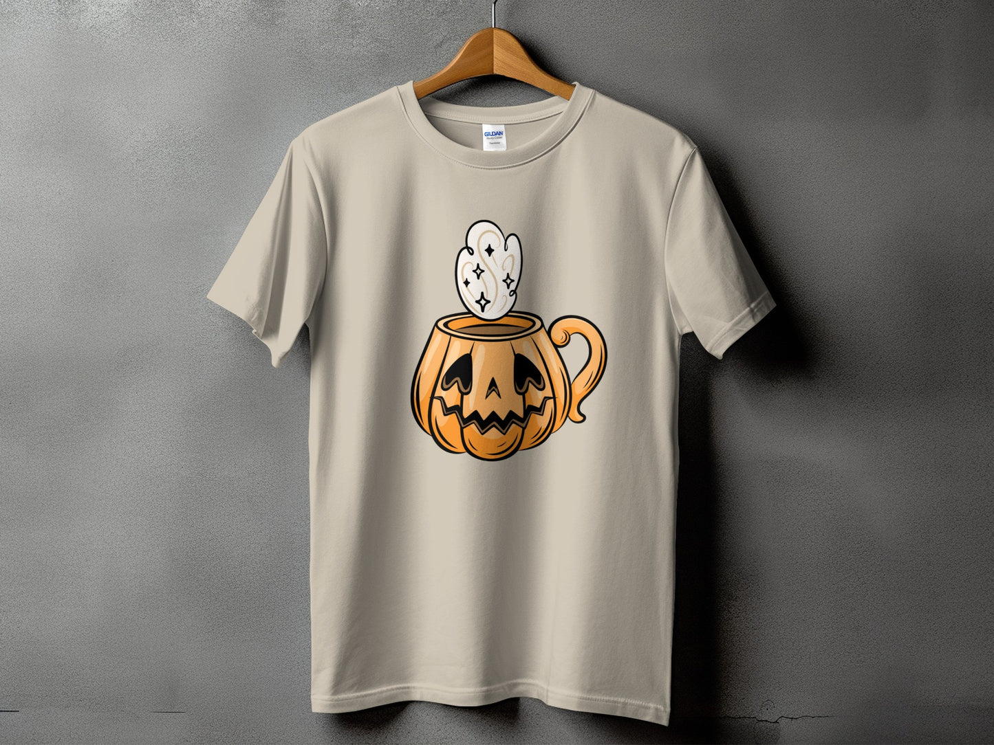 Tan t-shirt with a jack-o'-lantern mug graphic featuring spooky eyes and steam.