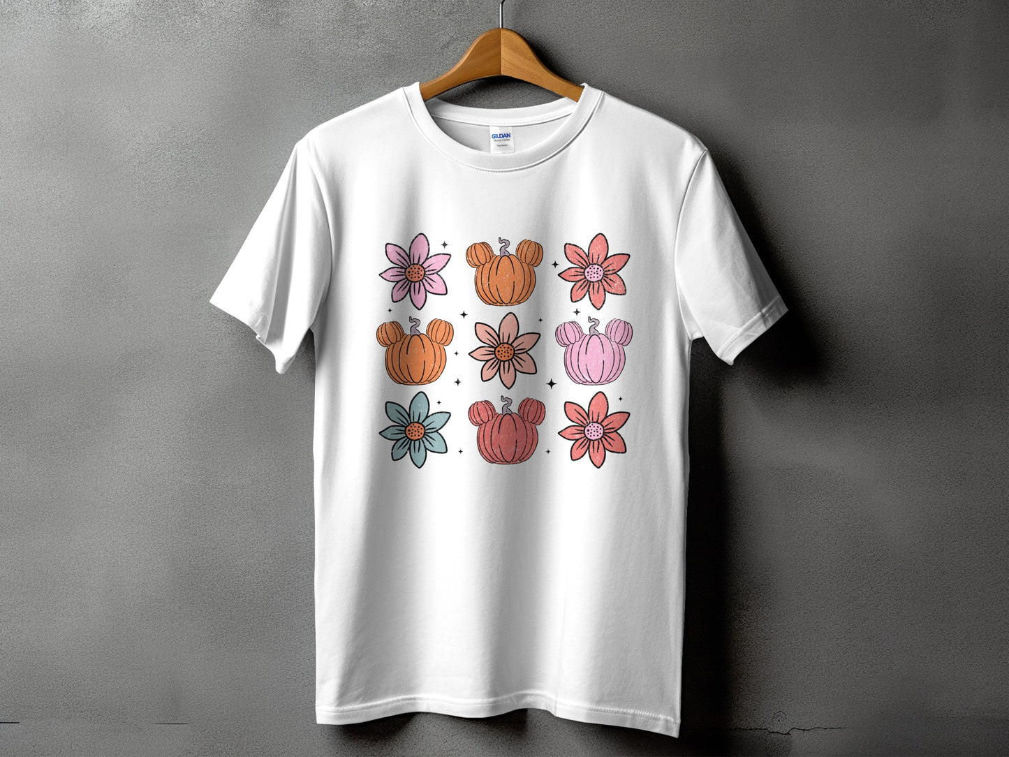 White t-shirt with nine cartoon pumpkins and flowers design.