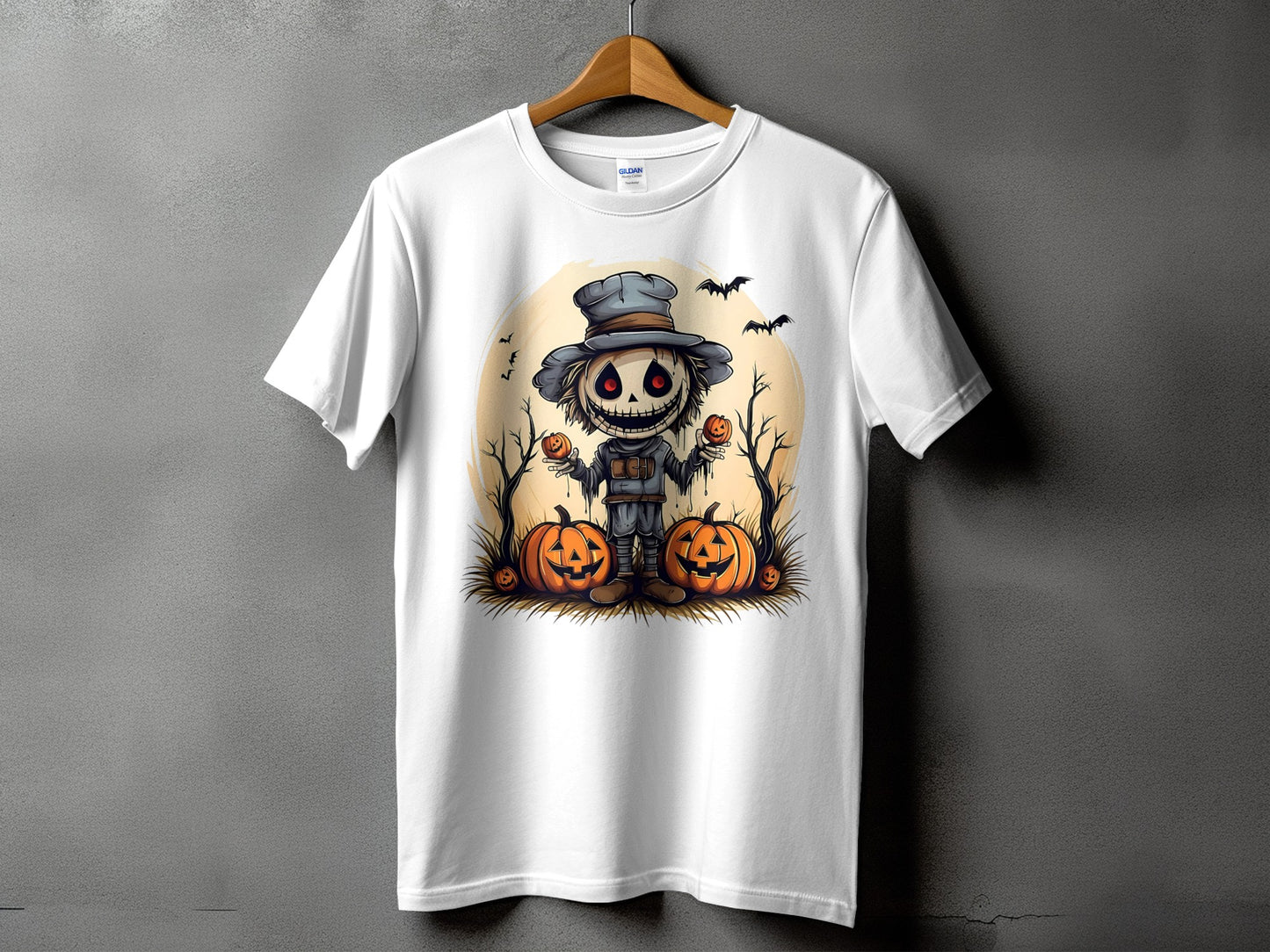 Scarecrow with pumpkins and bats on a white t-shirt with Gildan branding.