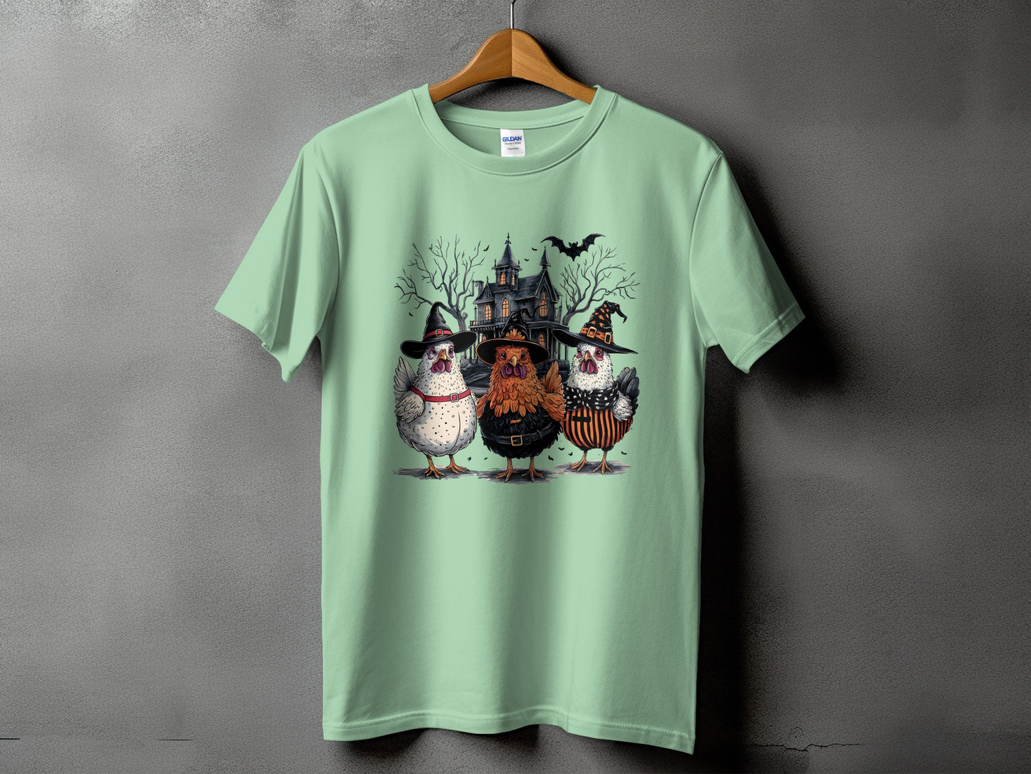Three chickens in Halloween costumes stand before a spooky house with bats.