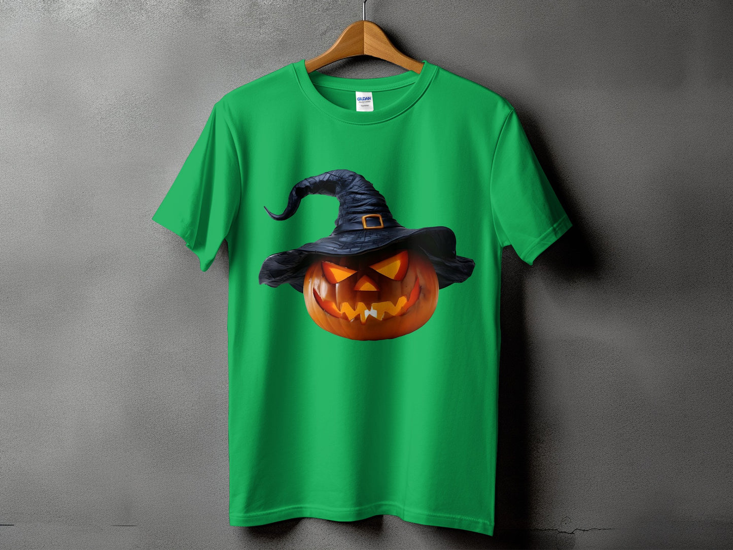 Green t-shirt with a graphic of a carved pumpkin wearing a witch hat.