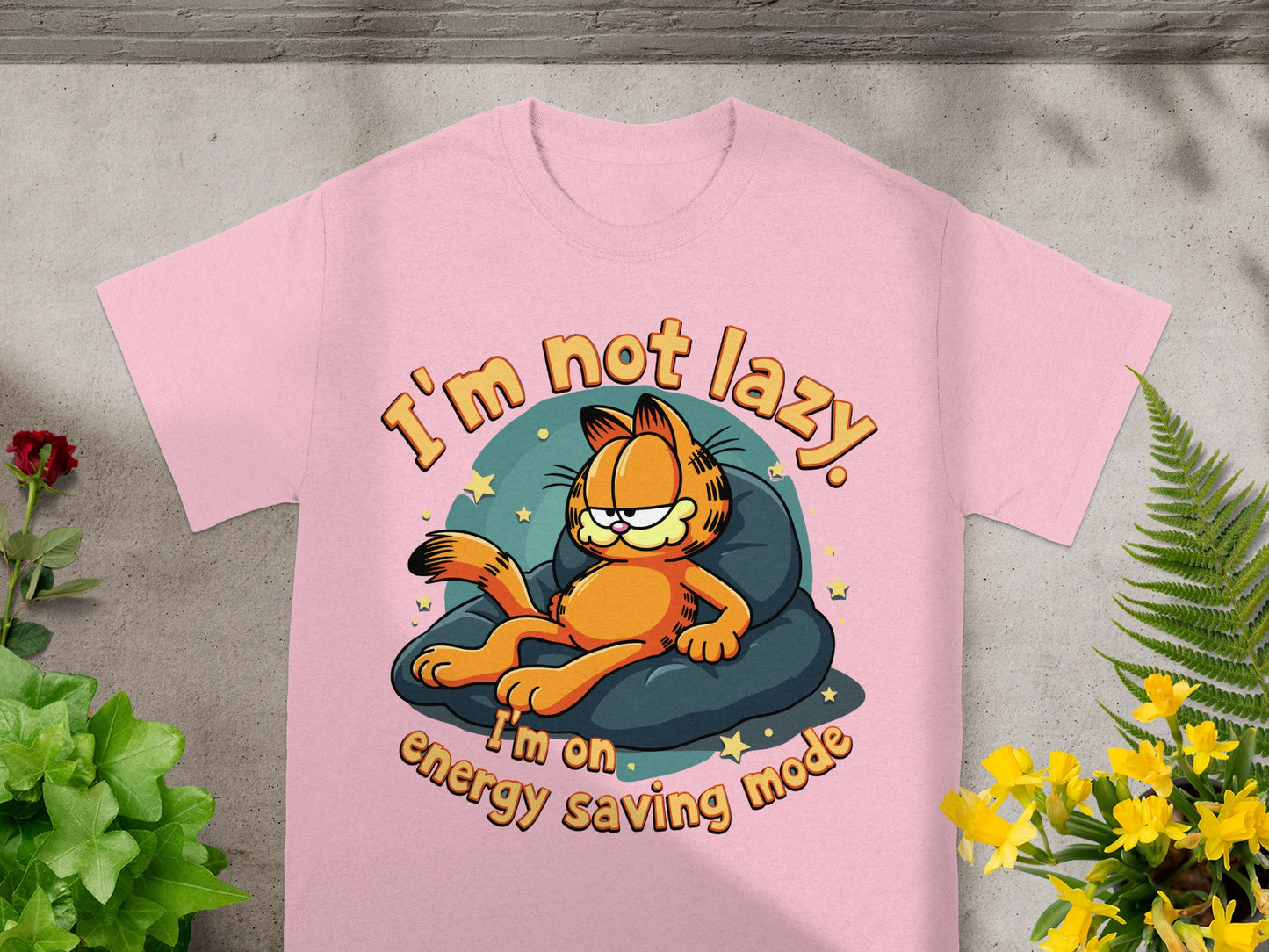 Pink t-shirt with Garfield on a cushion saying "I'm not lazy. I'm on energy saving mode."