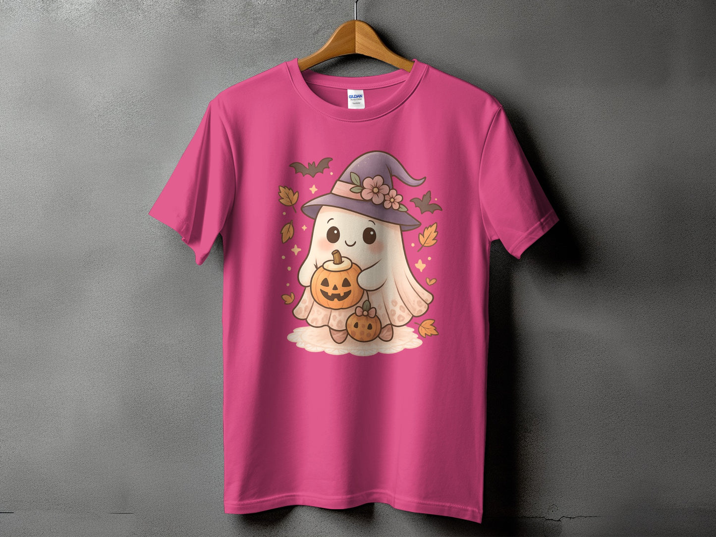 Pink t-shirt with a cute ghost character holding pumpkins and wearing a witch hat.