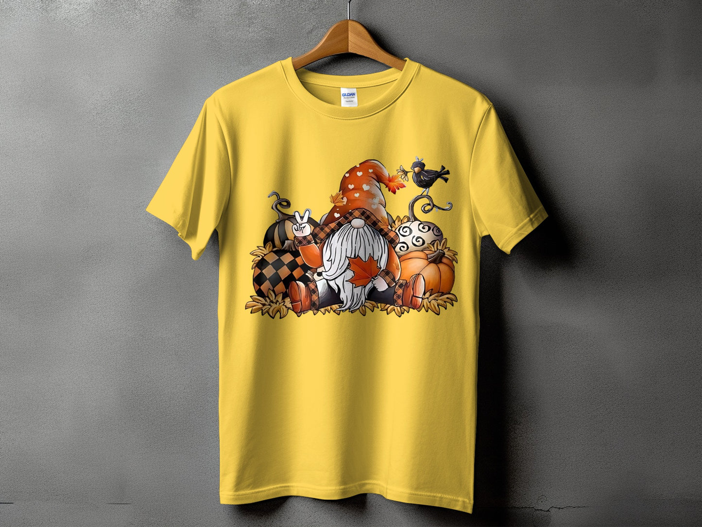 Yellow t-shirt with gnome and pumpkins graphic and "GILDAN" tag.