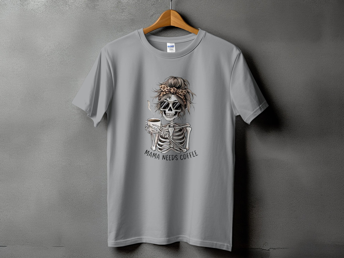 Grey t-shirt with skeleton graphic holding coffee, text "Mama Needs Coffee."
