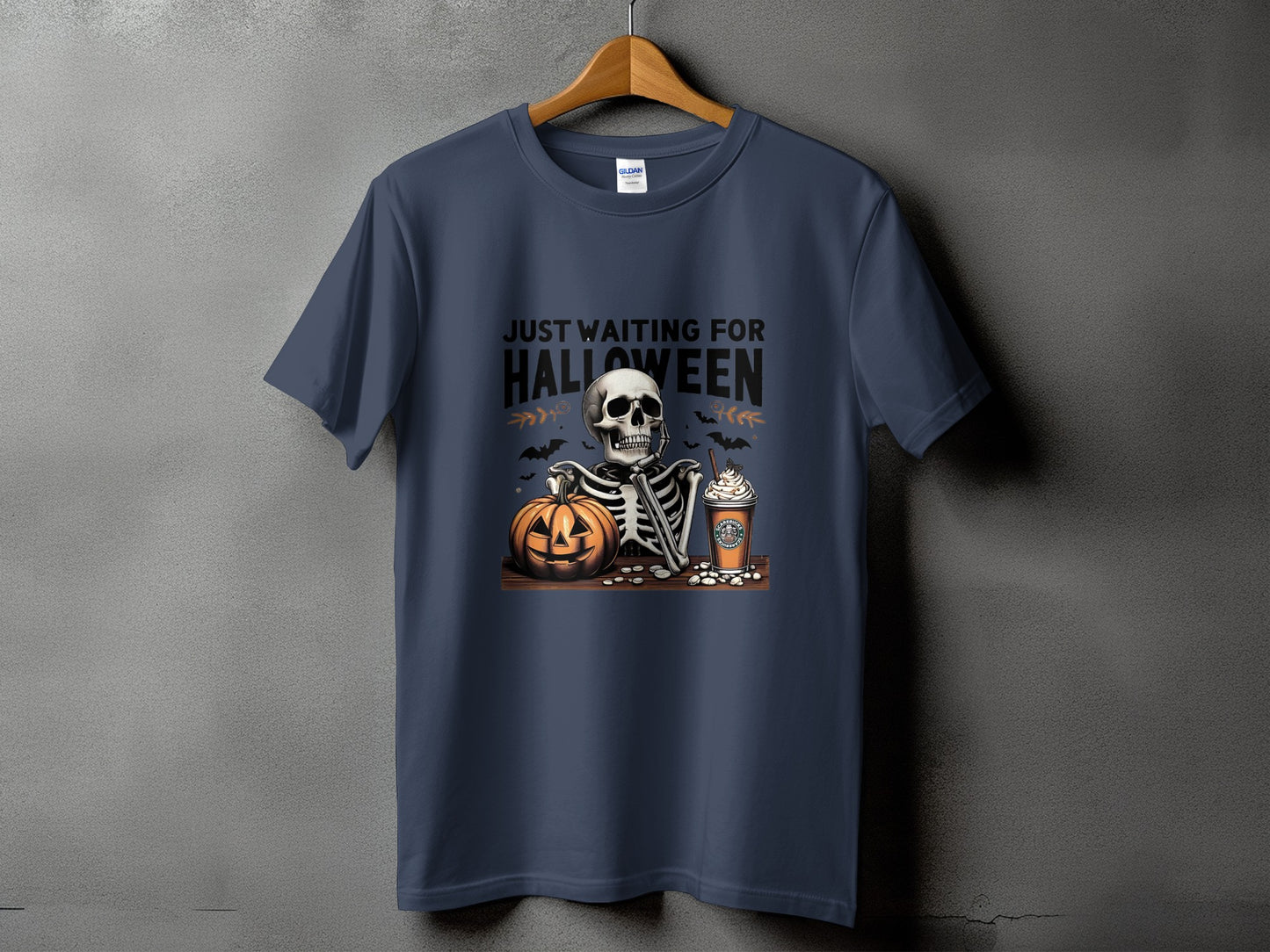 Skeleton with pumpkin and coffee cup on t-shirt with text "Just Waiting for Halloween".