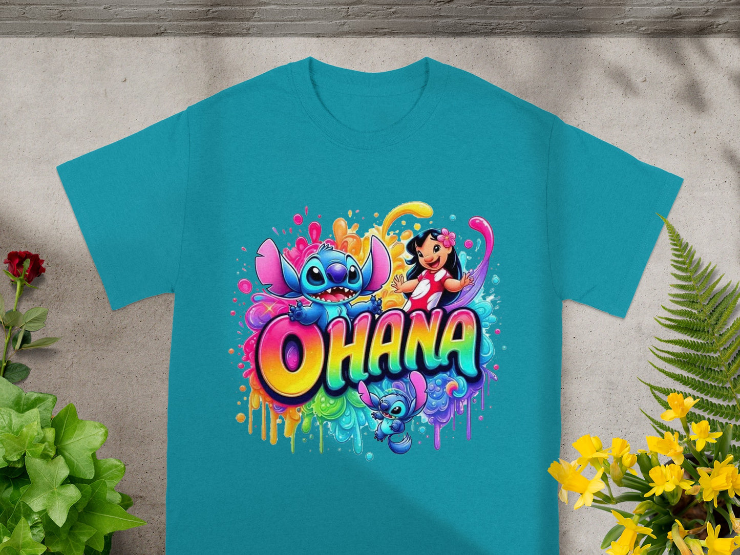 "Ohana" graphic with Stitch and Lilo in colorful paint splatter on a turquoise t-shirt.