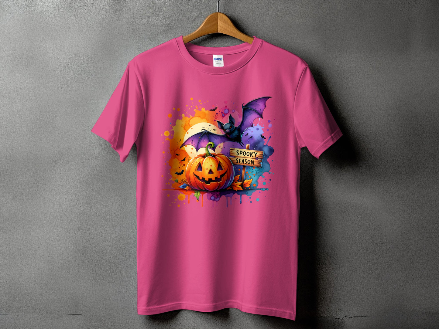Pink t-shirt with Halloween graphic of pumpkin, bat, and "Spooky Season" sign.