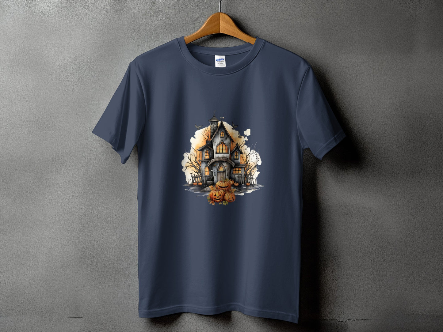 Dark blue t-shirt with a watercolor illustration of a haunted house and pumpkins.