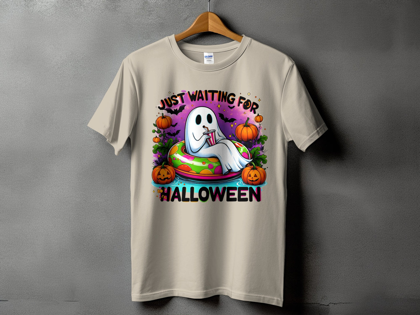 Ghost floating in a pool ring with pumpkins and bats, text "Just Waiting For Halloween."
