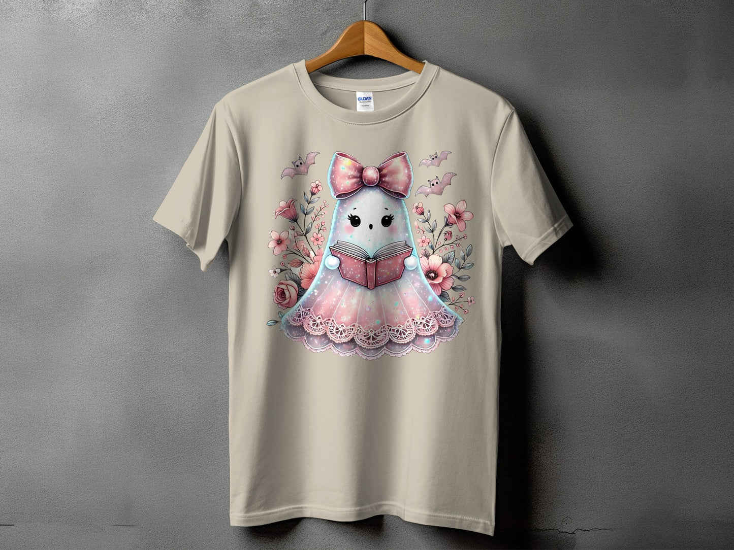 T-shirt with a cute ghost reading a book surrounded by flowers and bats.