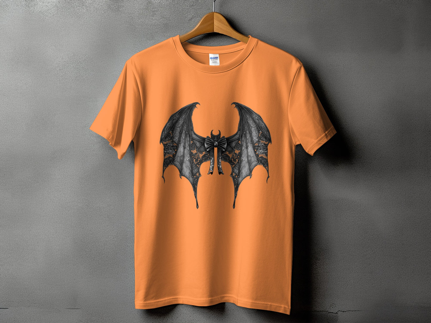 Orange t-shirt with a detailed black bat wing design and a bow.