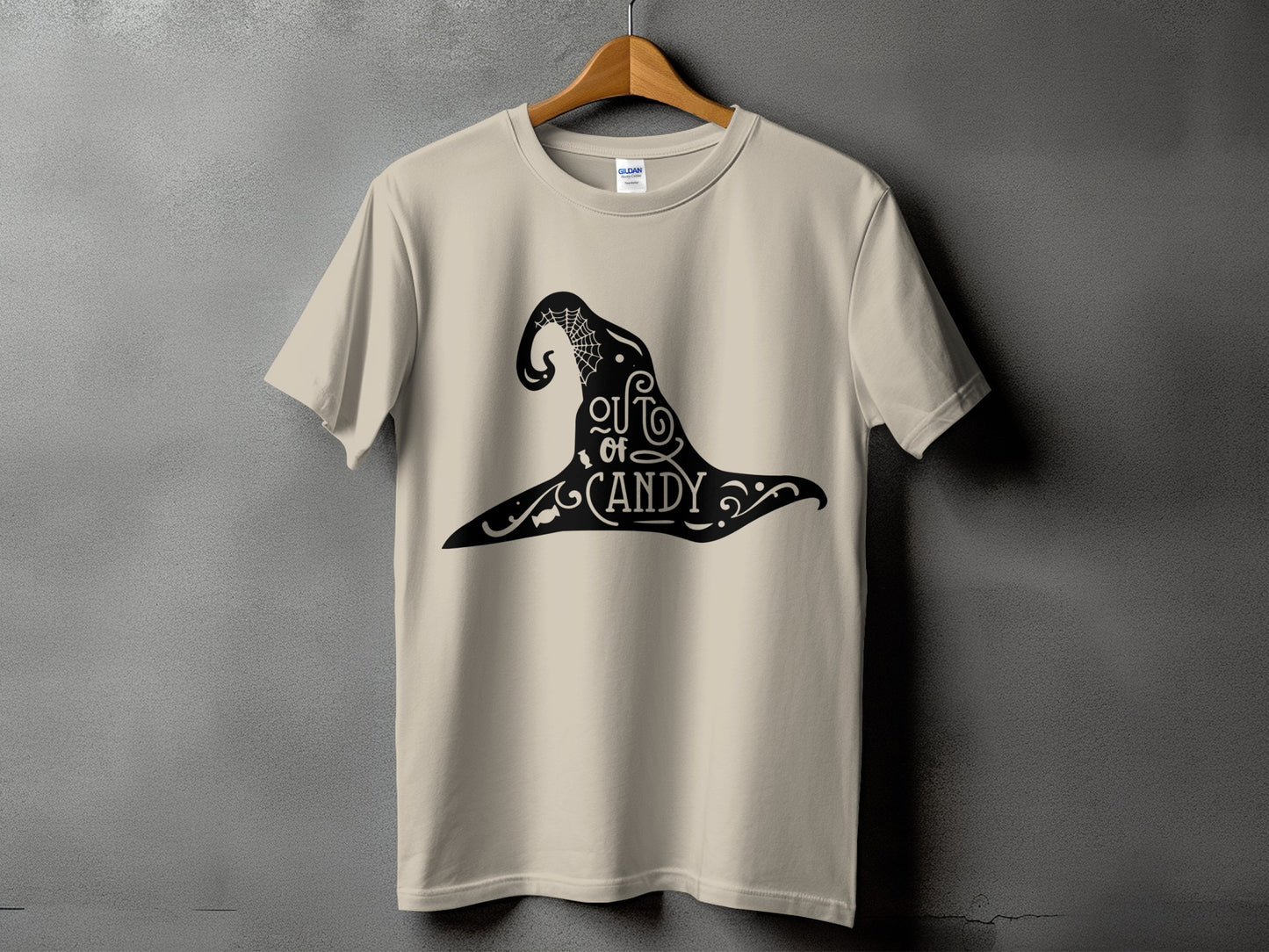 Beige t-shirt with black witch hat graphic that reads "out of candy".