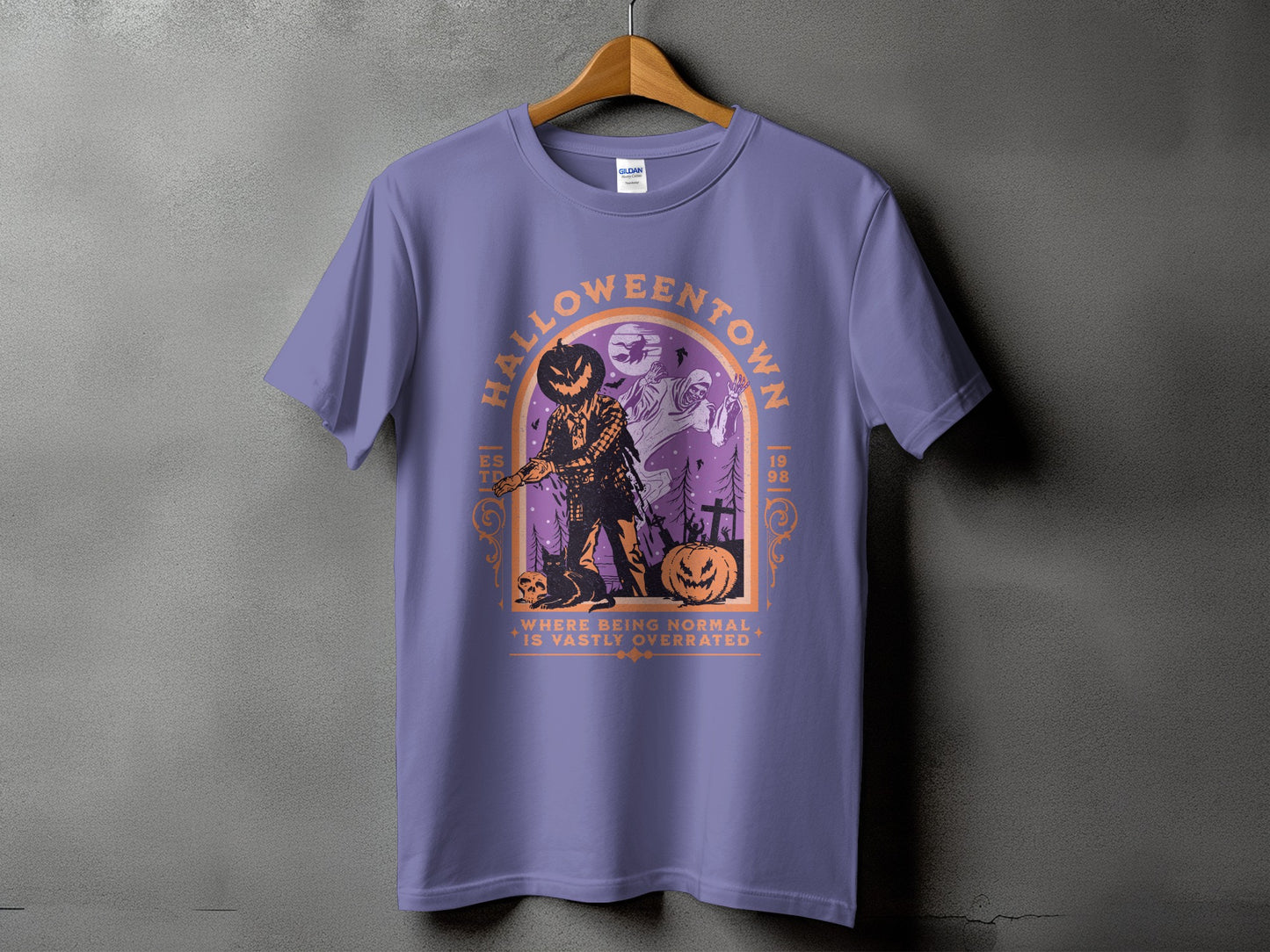 Purple t-shirt with a Halloween graphic featuring a scarecrow, ghost, and pumpkins.