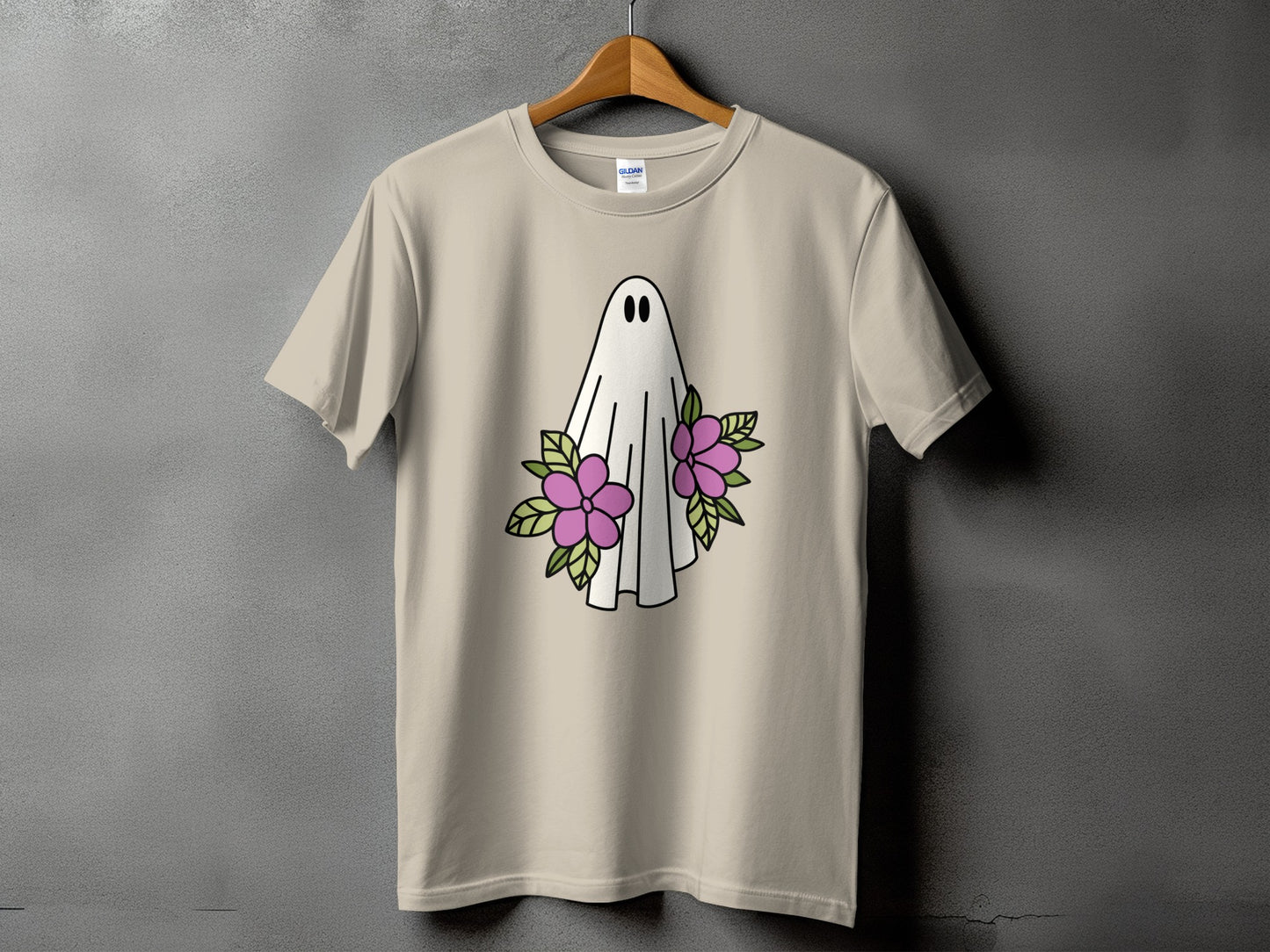 Light tan t-shirt with a cartoon ghost and pink flowers graphic.