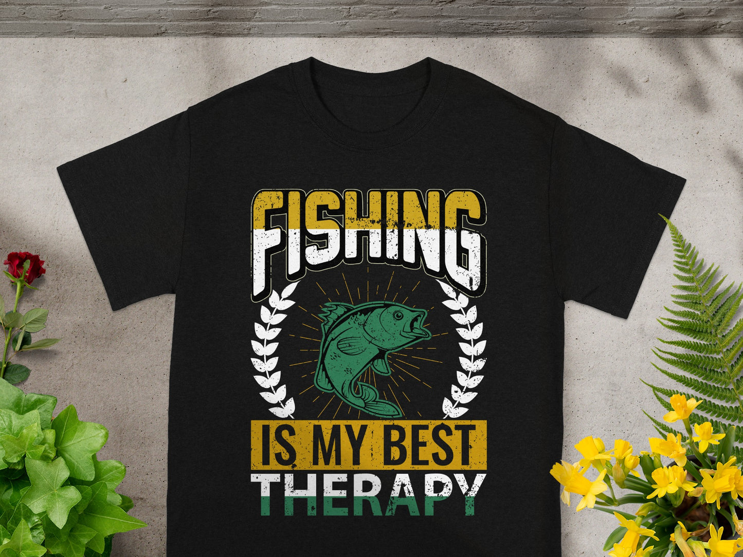 Black t-shirt with "FISHING IS MY BEST THERAPY" text and a green fish graphic.