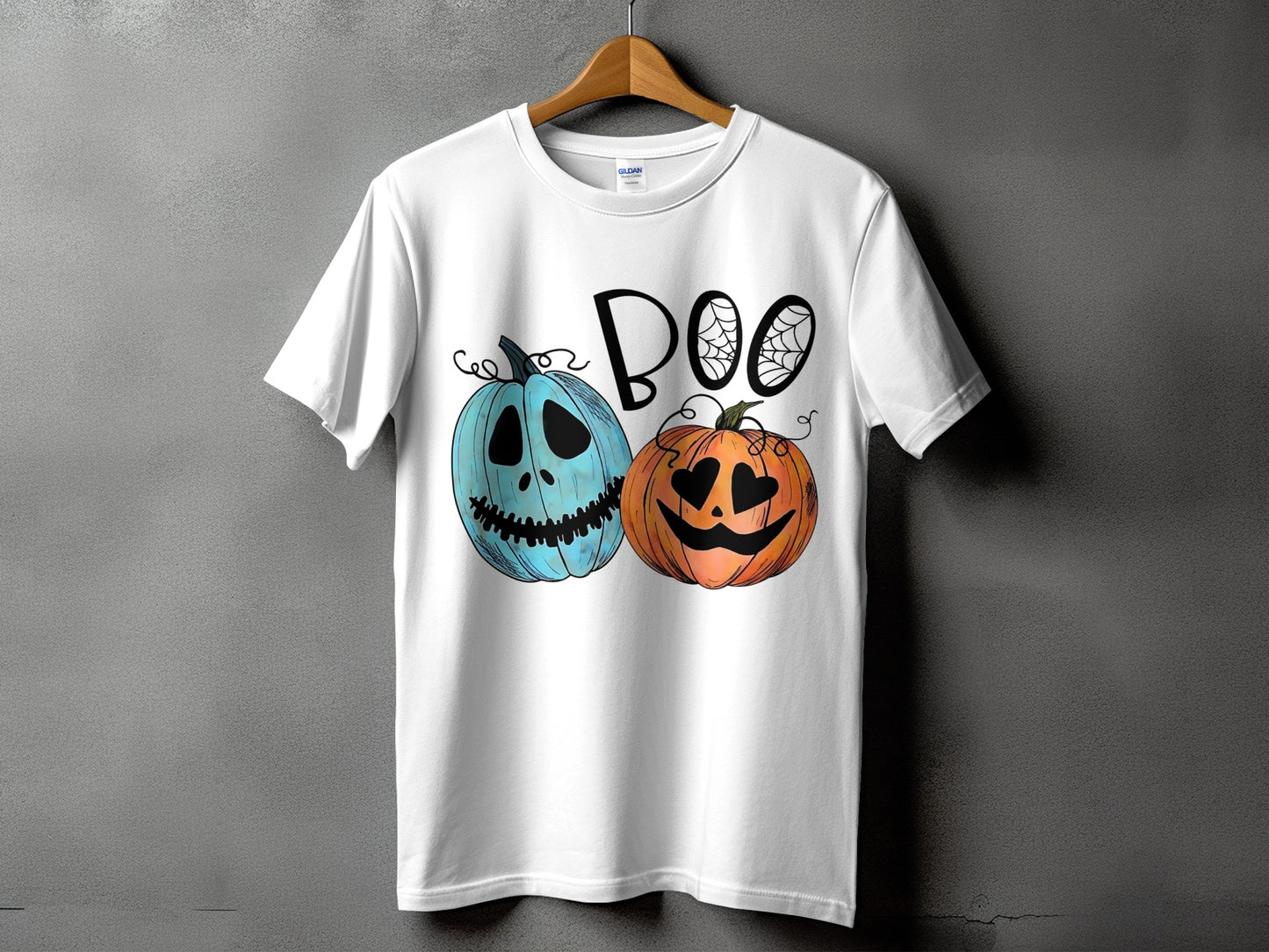 White t-shirt with "BOO" text and two cartoon pumpkins, one blue and one orange.