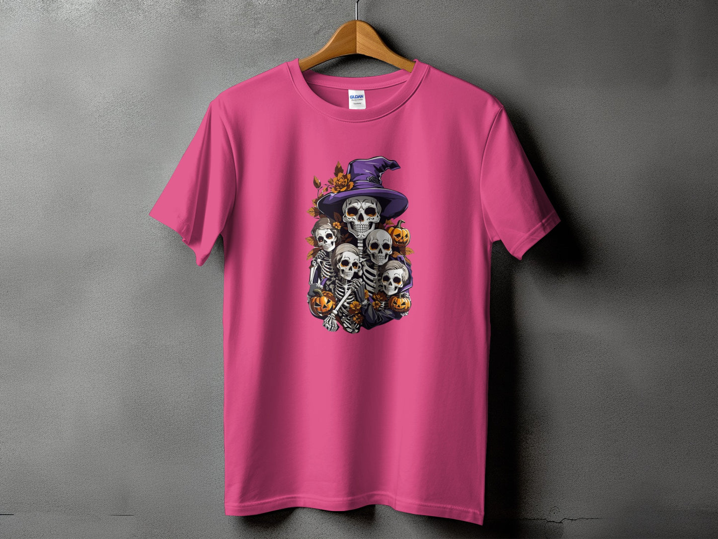 Pink t-shirt with Halloween skeletons wearing a witch hat and pumpkins graphic.