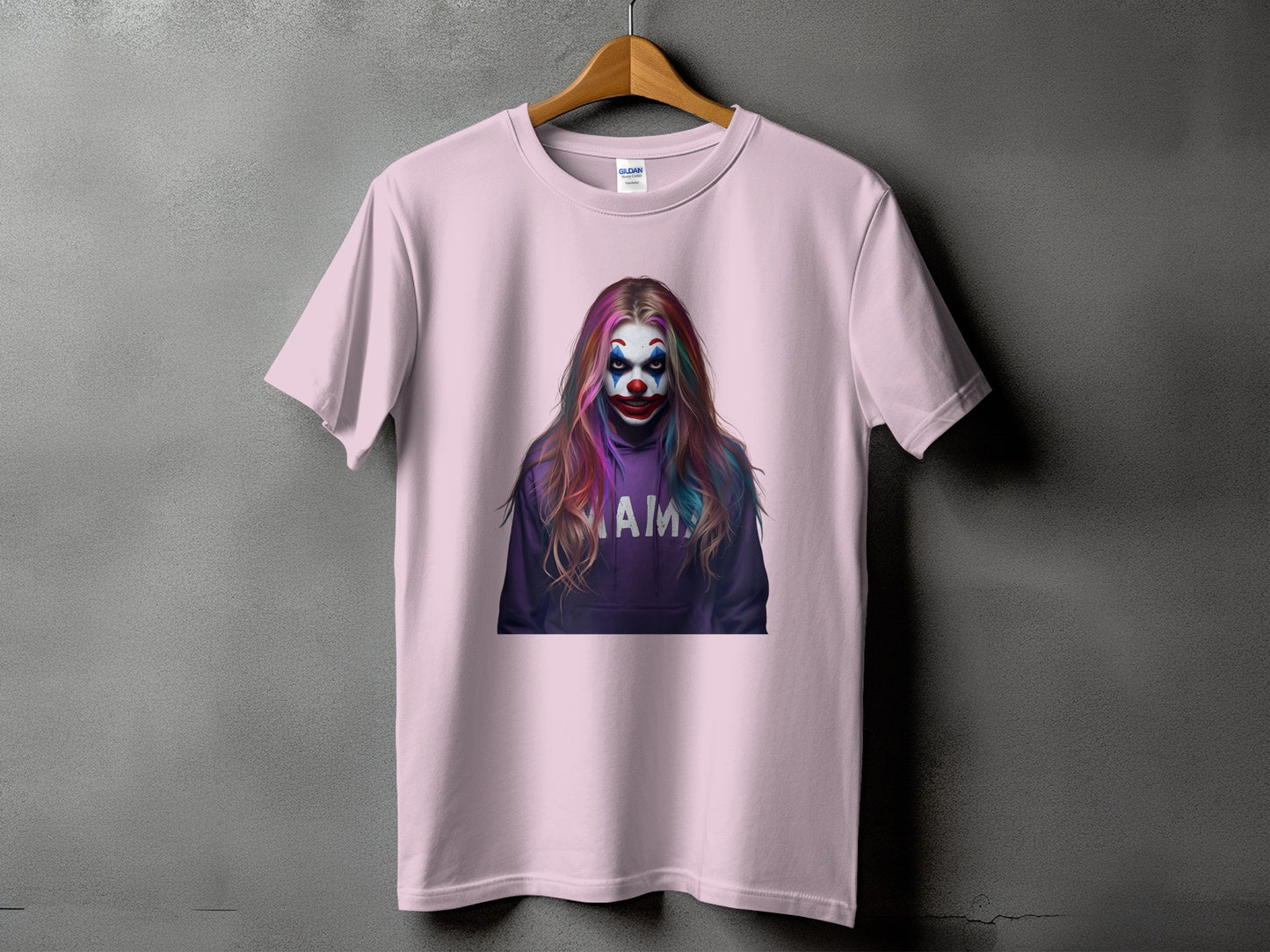 Pink t-shirt with a graphic of a clown wearing a purple hoodie with "MAIM" on it.