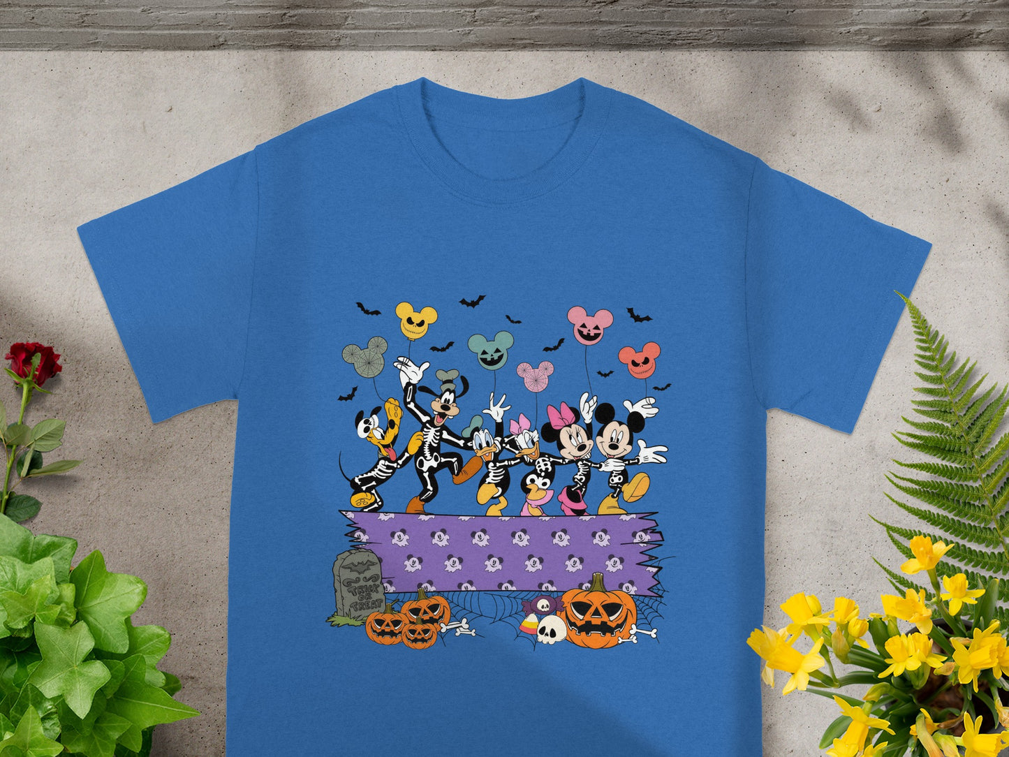 Mickey Mouse characters in skeleton costumes celebrate Halloween with pumpkins and balloons.