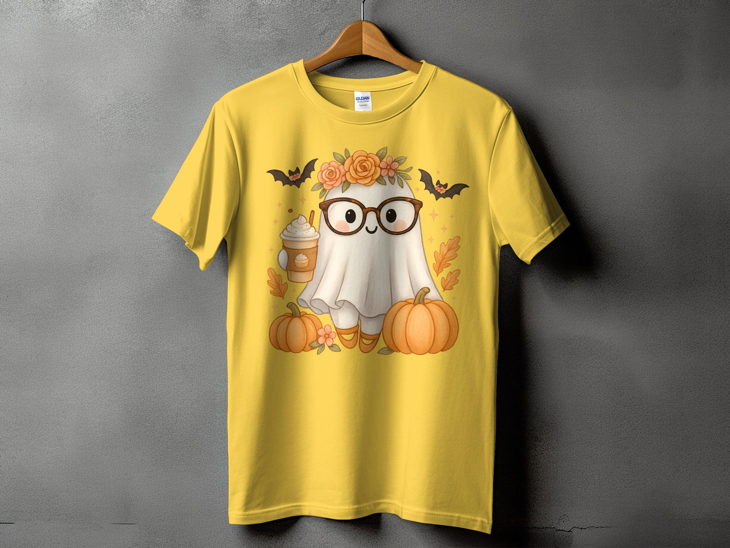 Yellow t-shirt with a cute ghost wearing glasses, holding a coffee, and surrounded by pumpkins.