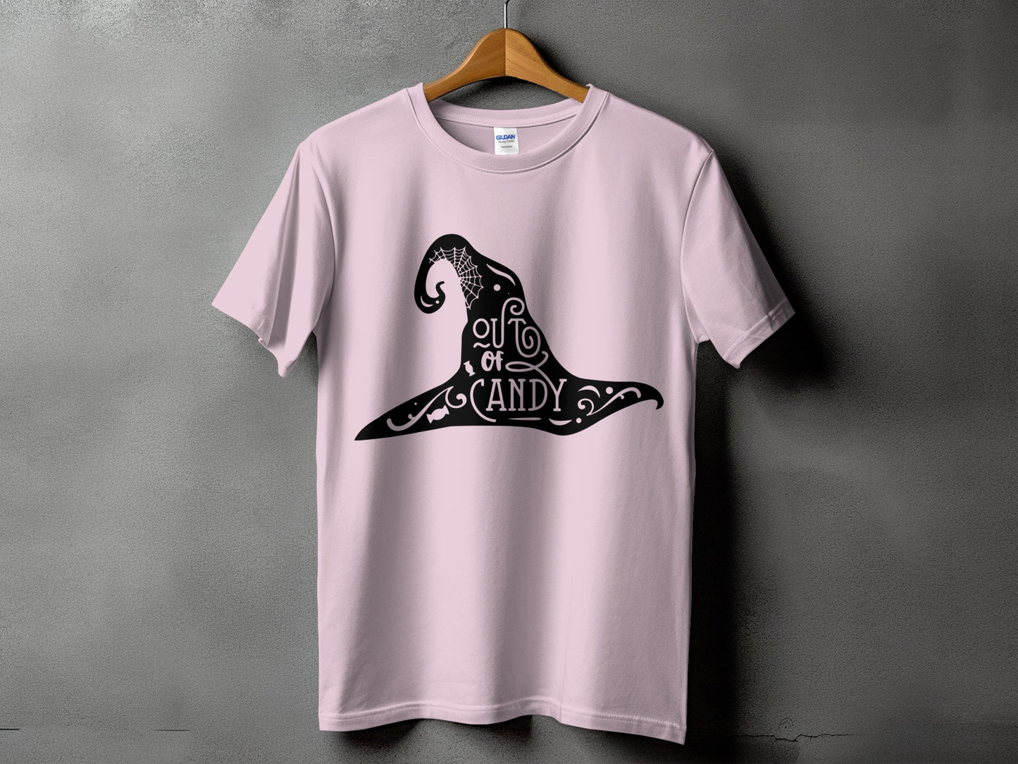 Pink t-shirt with black witch hat graphic that says "out of candy".
