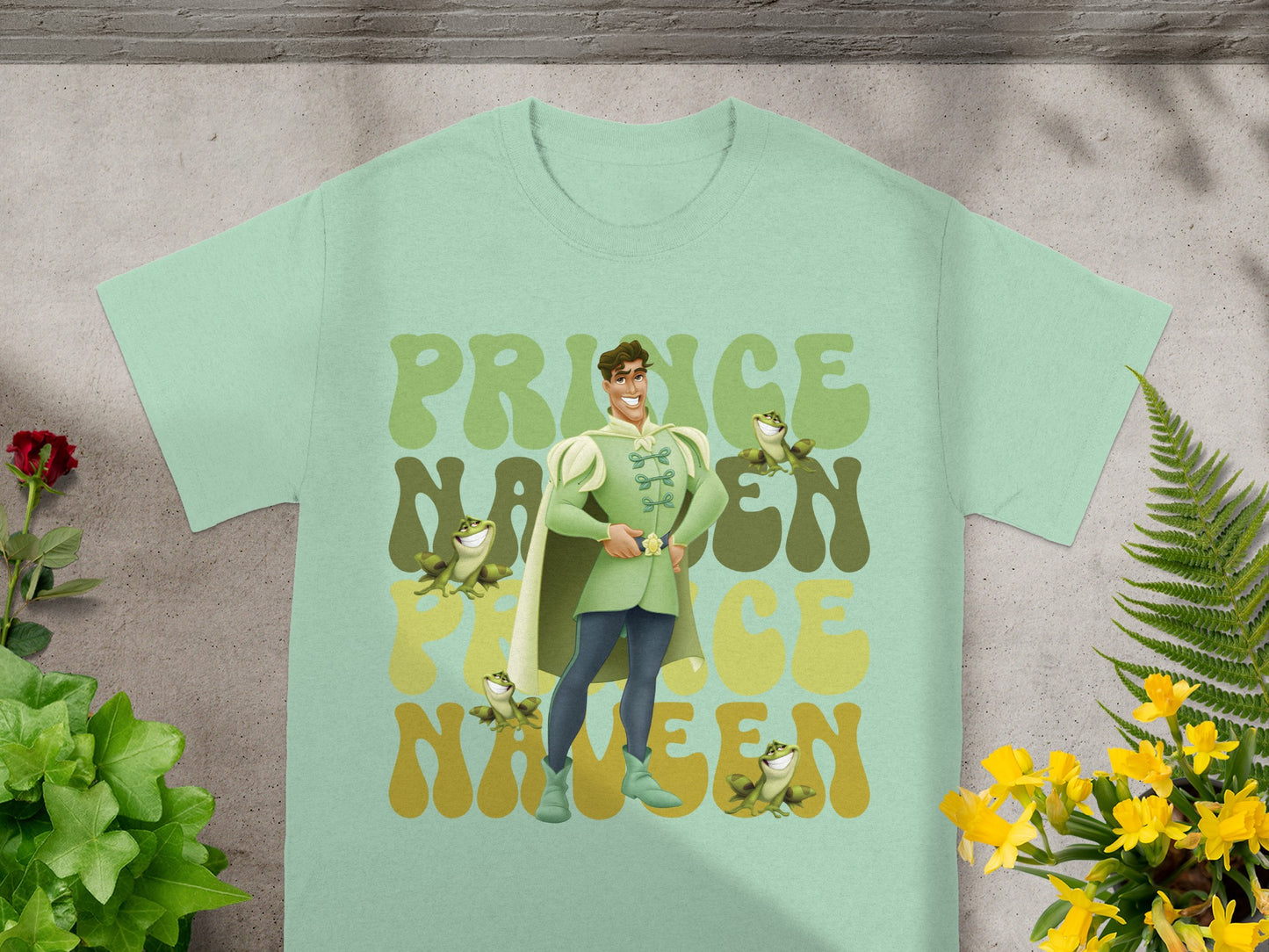 Prince Charming and frogs graphic on a mint green t-shirt.