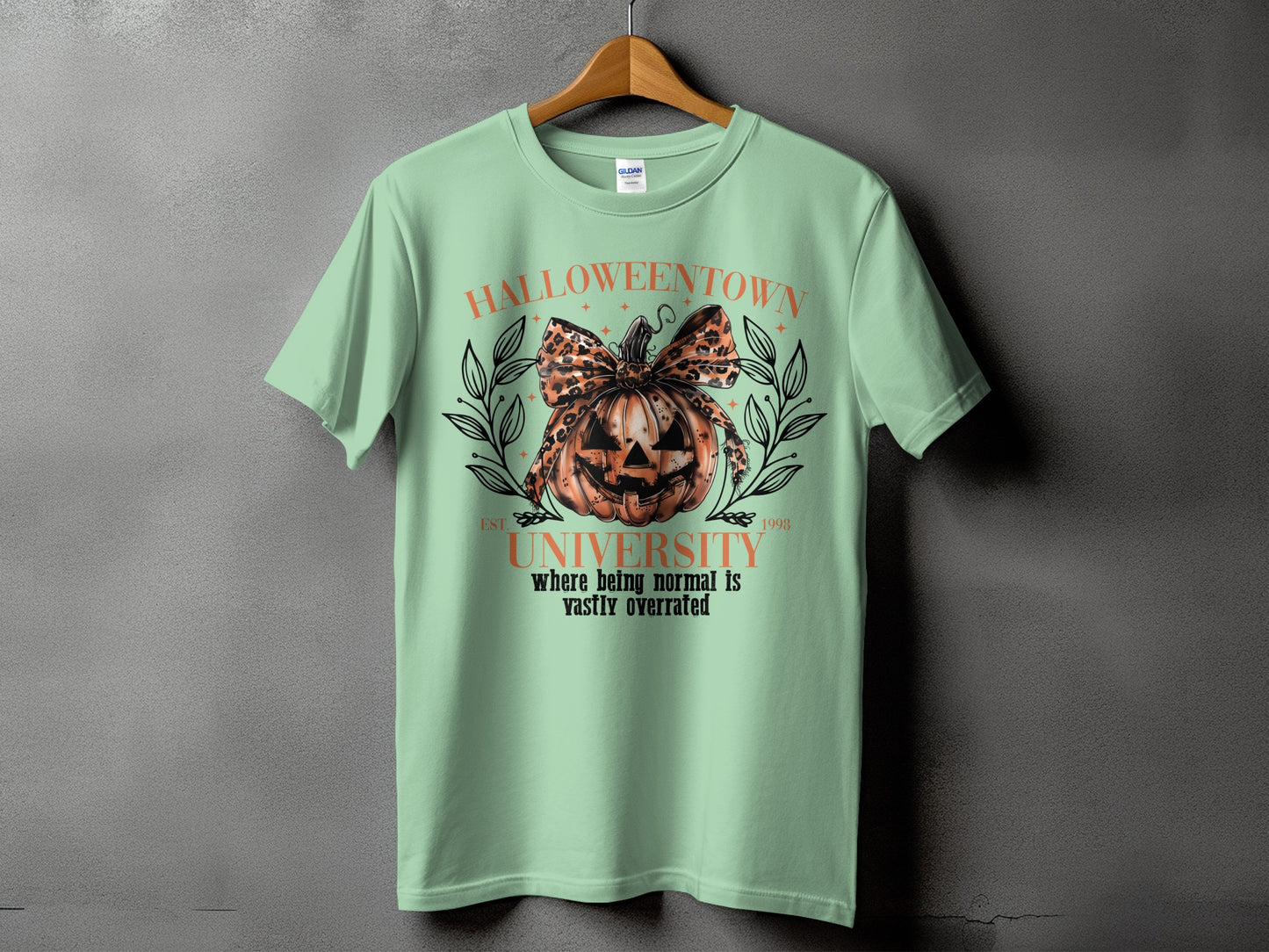 Light green t-shirt with a pumpkin graphic and "Halloweentown University" text.