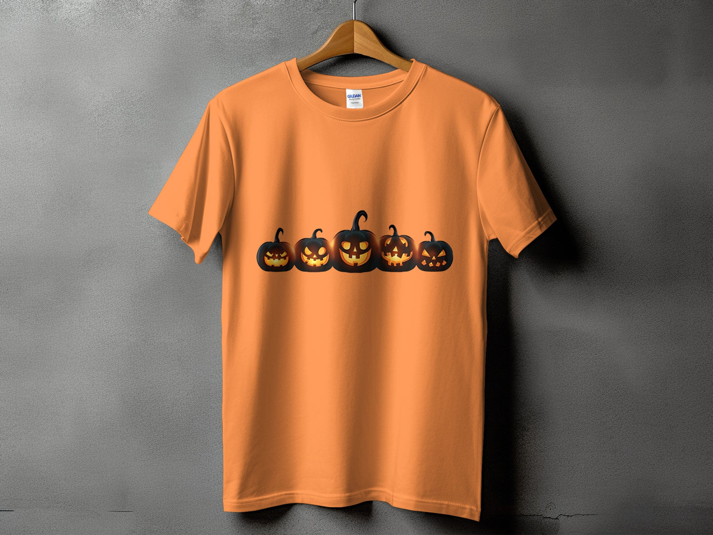 Orange t-shirt with a row of five carved, glowing jack-o'-lanterns.