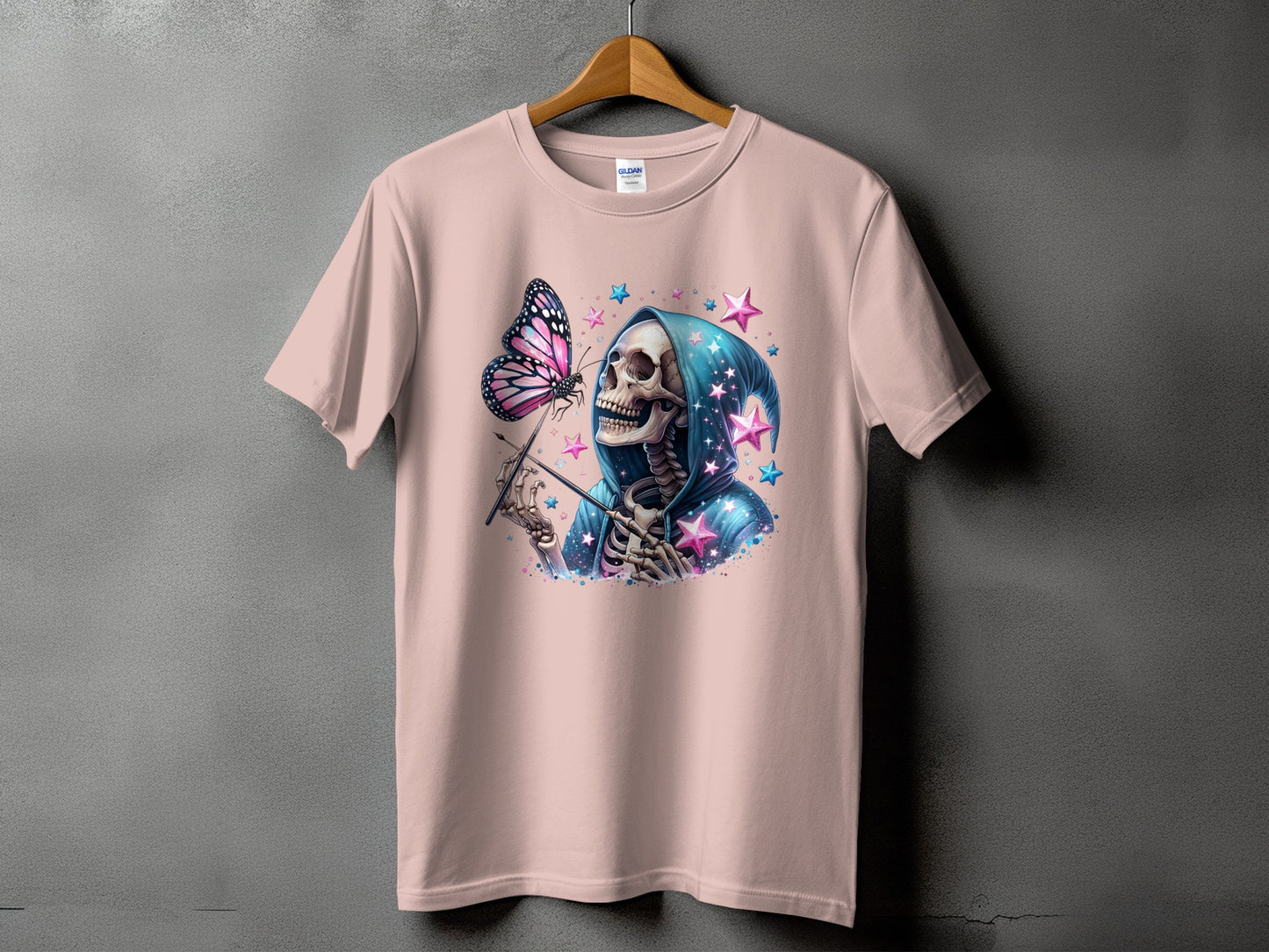 Skeleton in a hooded robe with a butterfly and stars graphic on a pink t-shirt.