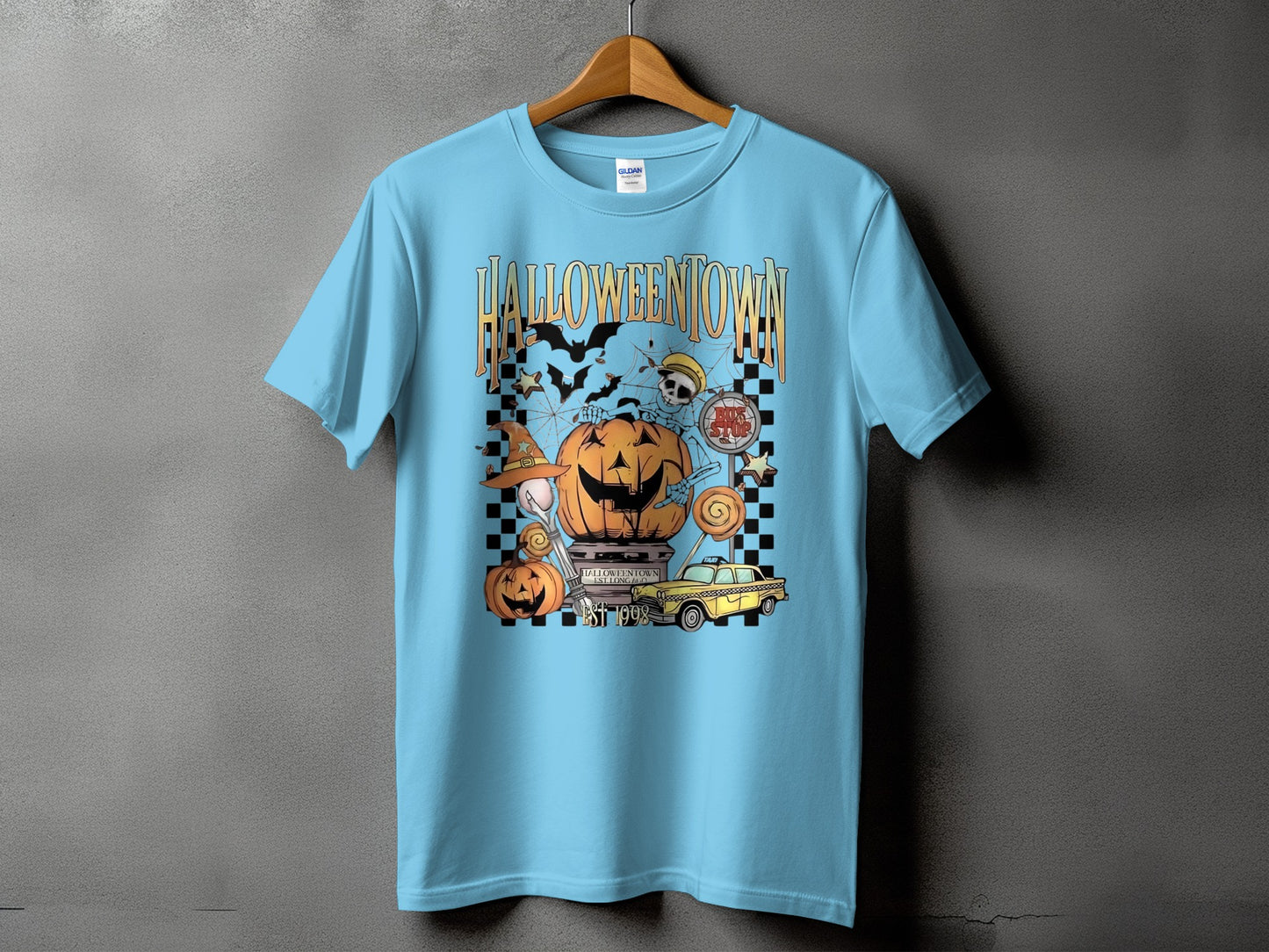 Light blue t-shirt with Halloween graphic featuring pumpkins, skeletons, bats, and the text "HALLOWEENTOWN EST 1998".