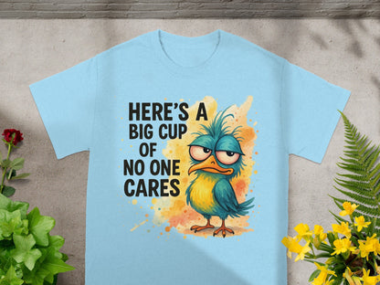 Light blue t-shirt with a cartoon bird graphic and text "Here's a big cup of no one cares".